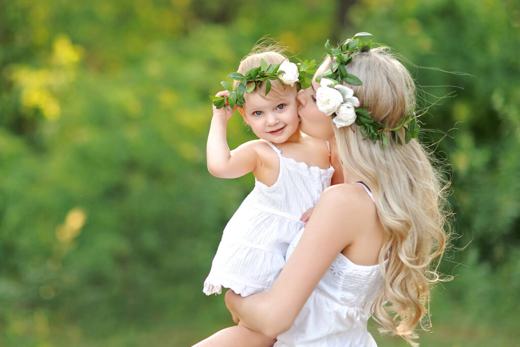 Kinderwillkommensfest Hannover – liebevoller Moment eines Kindes mit Mutter mit Blumenkranz